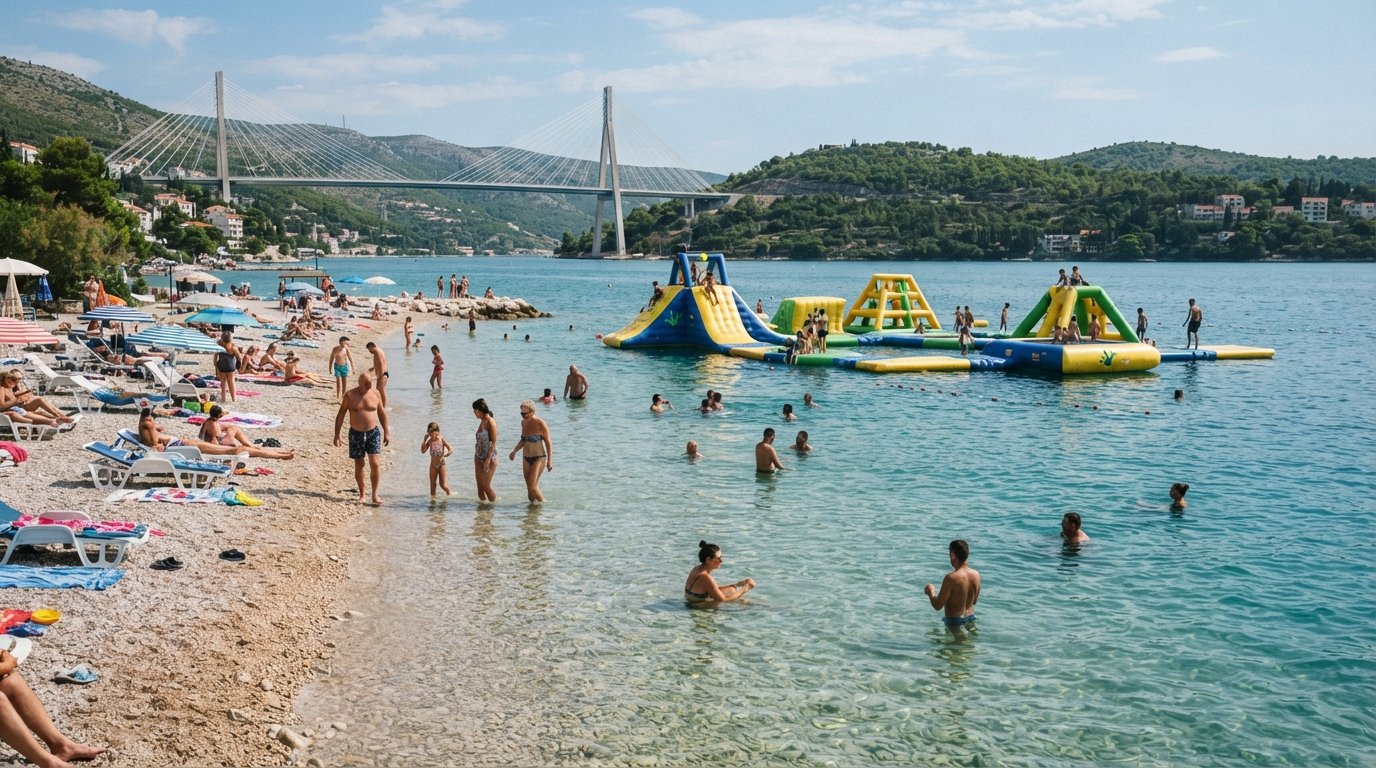 Copacabana Beach in Babin Kuk with shallow water, families, the floating Wibit inflatable water park and the Franjo Tuđman Bridge in the distance