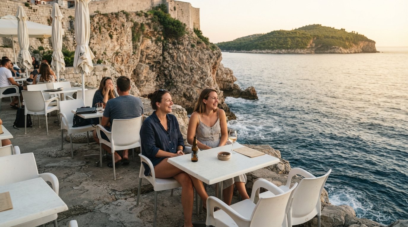 Cafe Buža on the southern wall, plastic tables perched above the Adriatic with Lokrum island visible across the water at golden hour